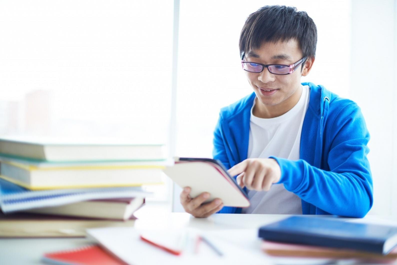 Students collaborating on financial analysis project with charts and laptops